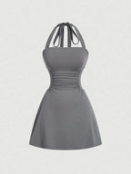 Women's sleeveless polka dot short dress with halter neckline and gathered back